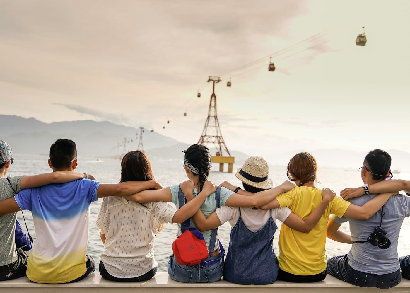 A group of friends sitting side by side with their arms around each other