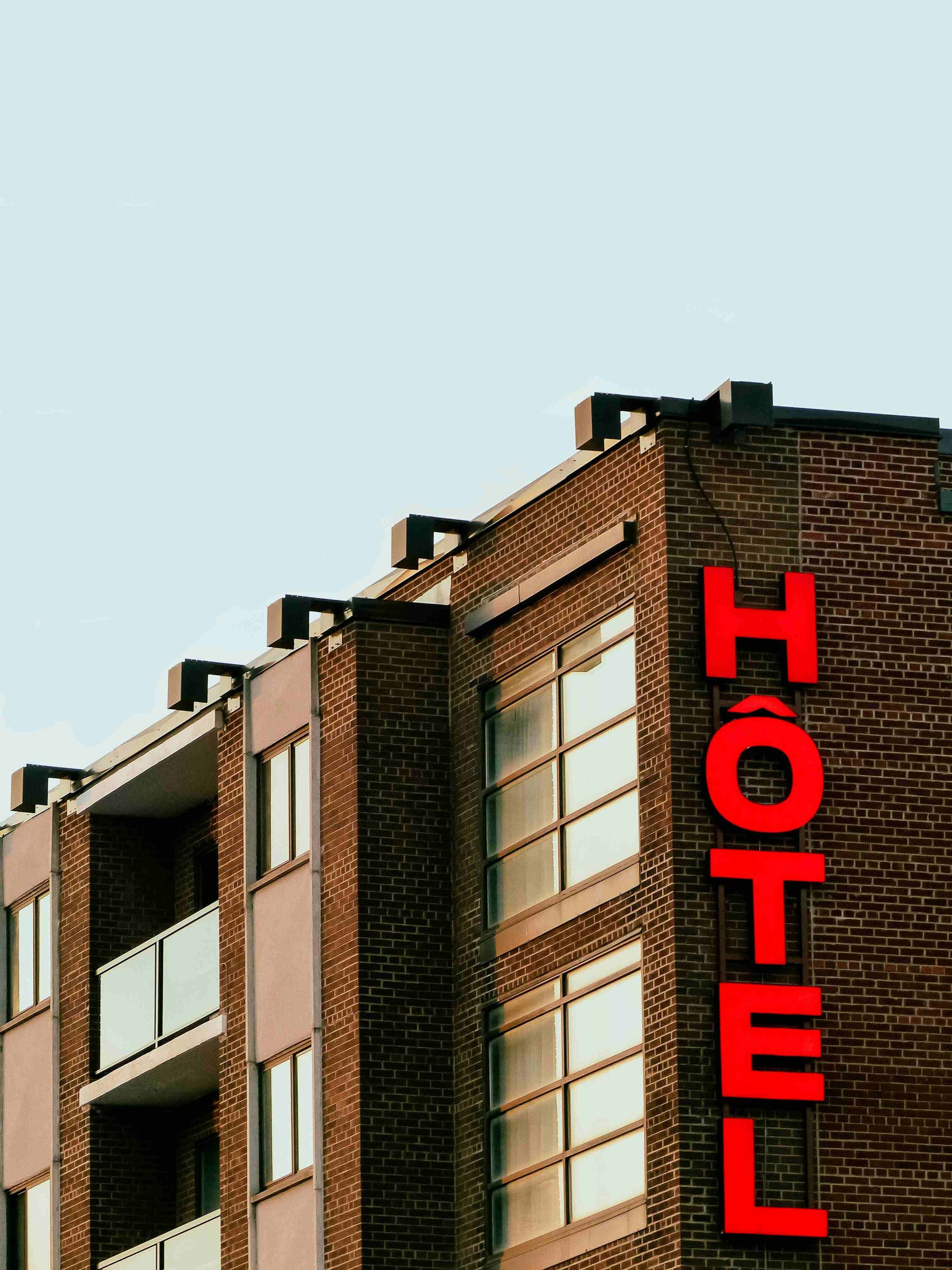 A hotel front with a red sign, one of the stay options for visitors