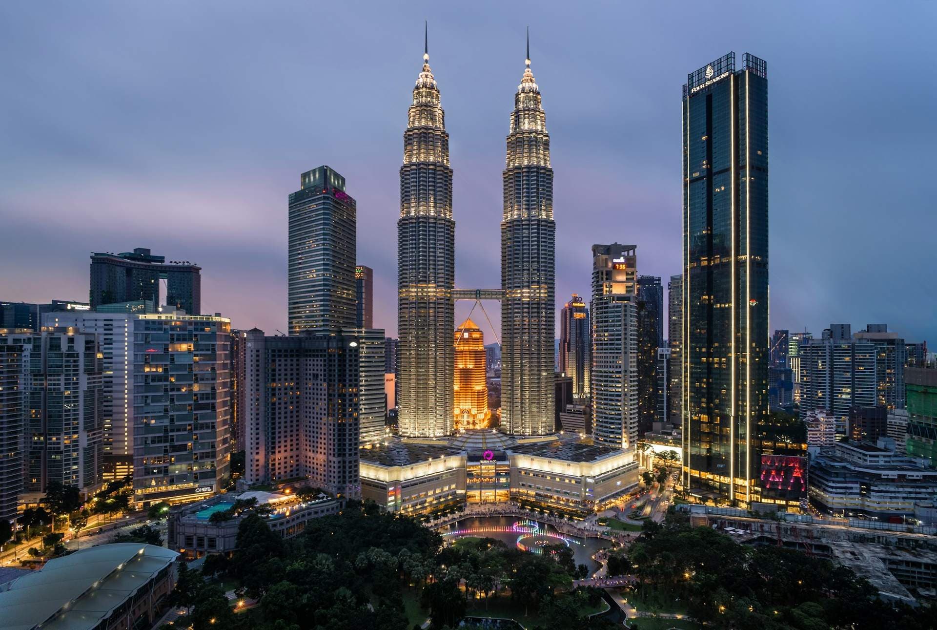 Menara Kembar Petronas dan cakrawala Kuala Lumpur saat senja, salah satu ikon wisata Malaysia